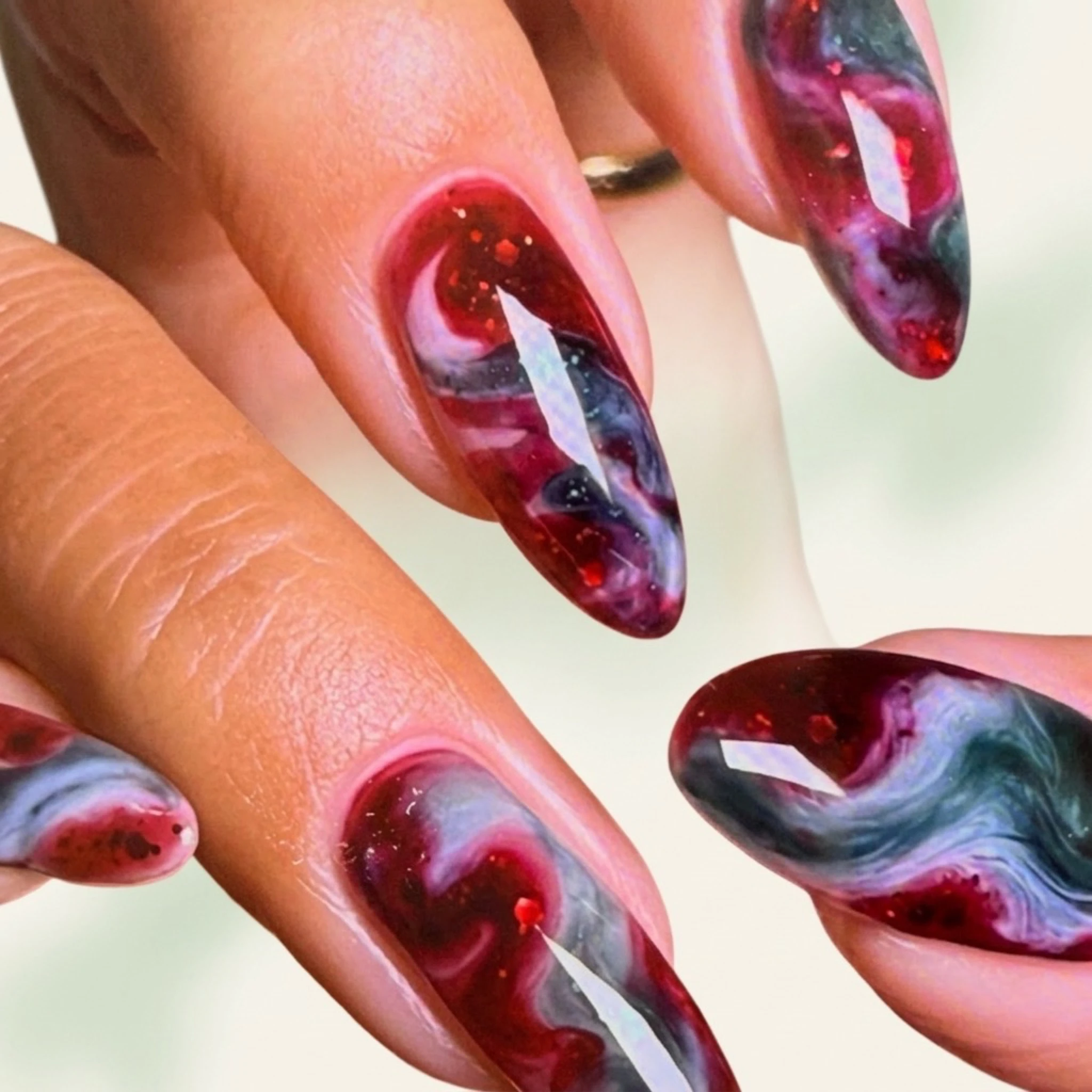 Galaxy marble swirl nail art — red, dark green and white abstract nail design